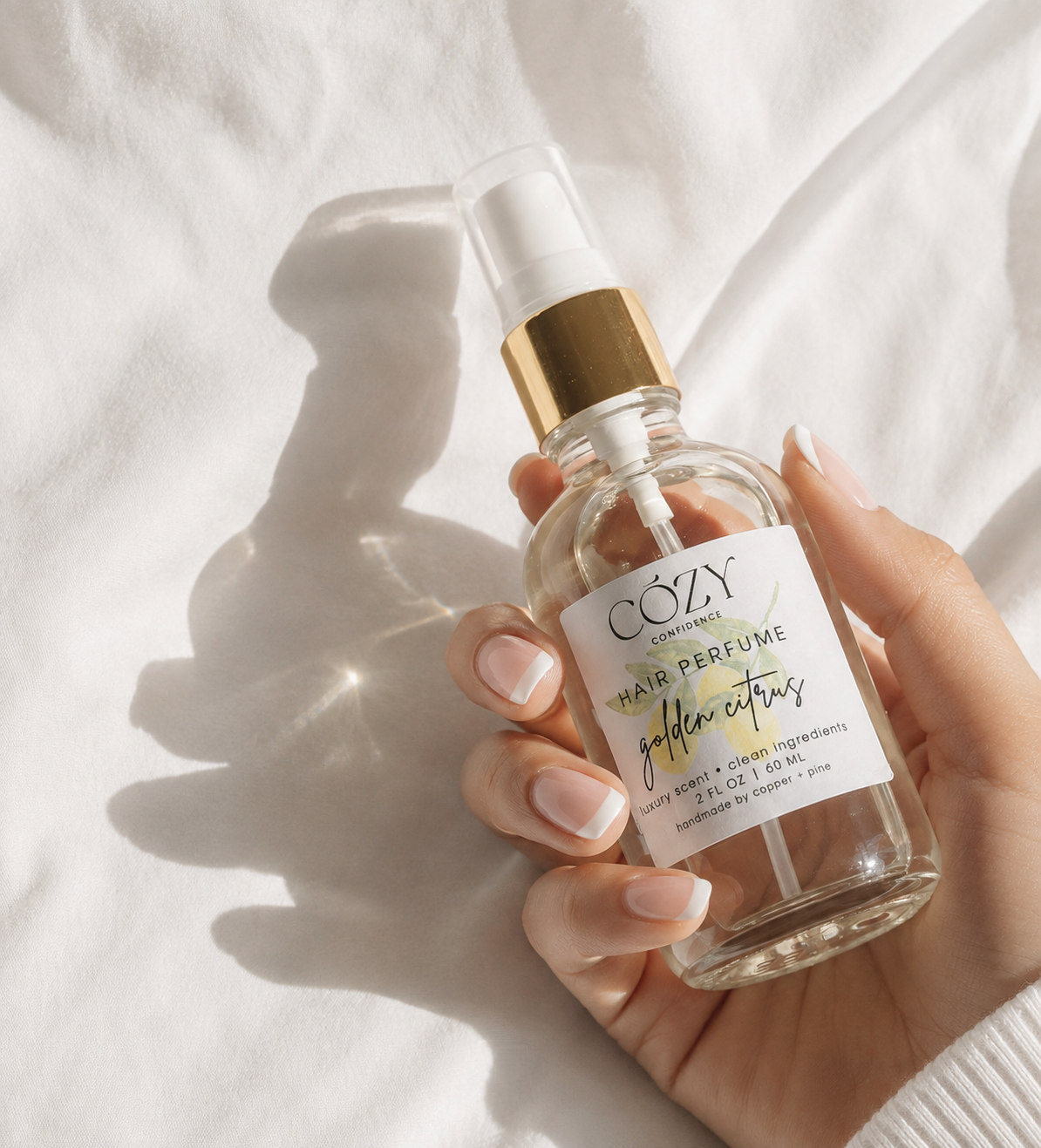 A clear glass bottle of non-toxic safe fragrance for hair, body and home. Rich golden citrus scent.