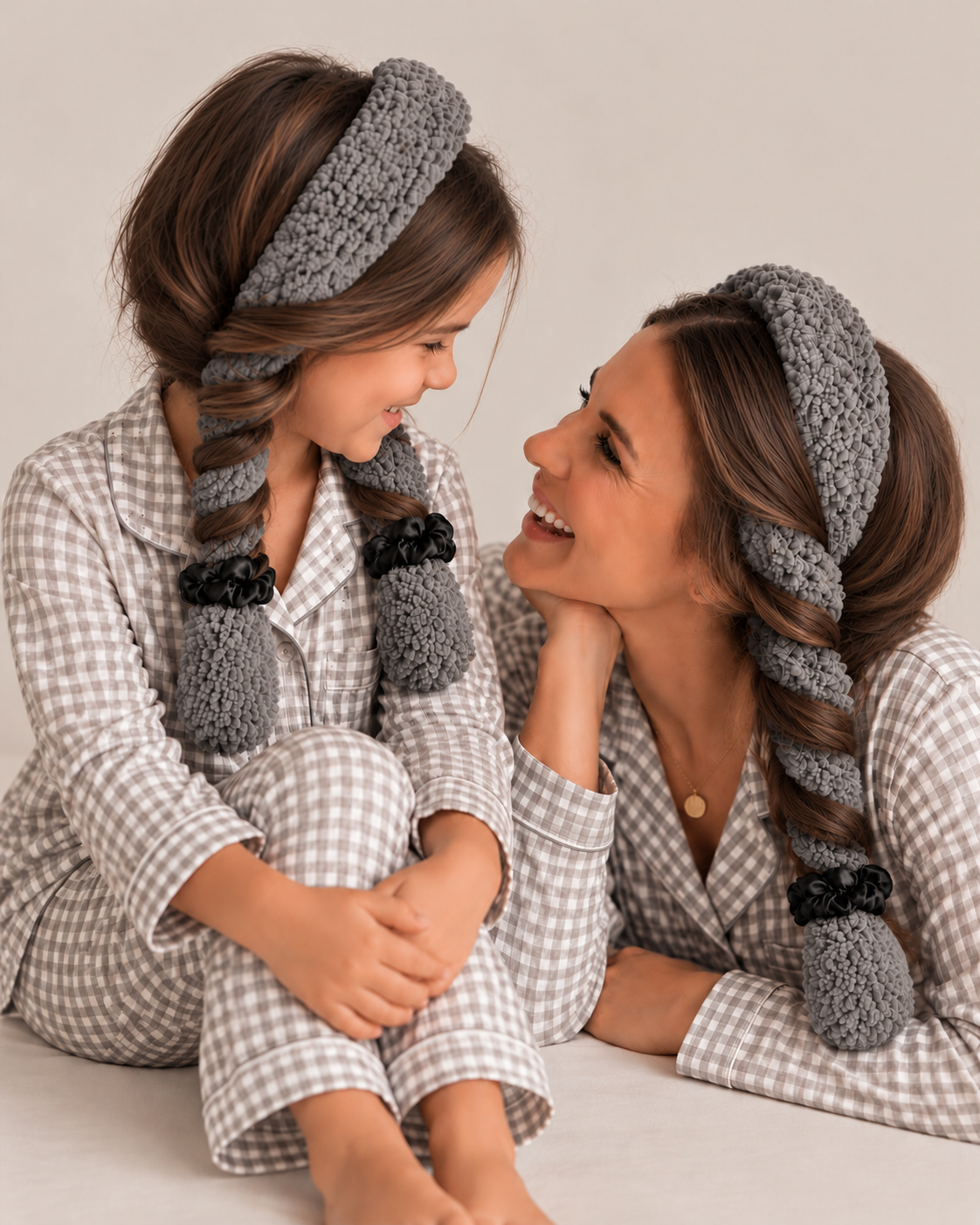 Mom and mini wearing matching slate grey CurlBands with black silk scrunchies in grey gingham pajamas