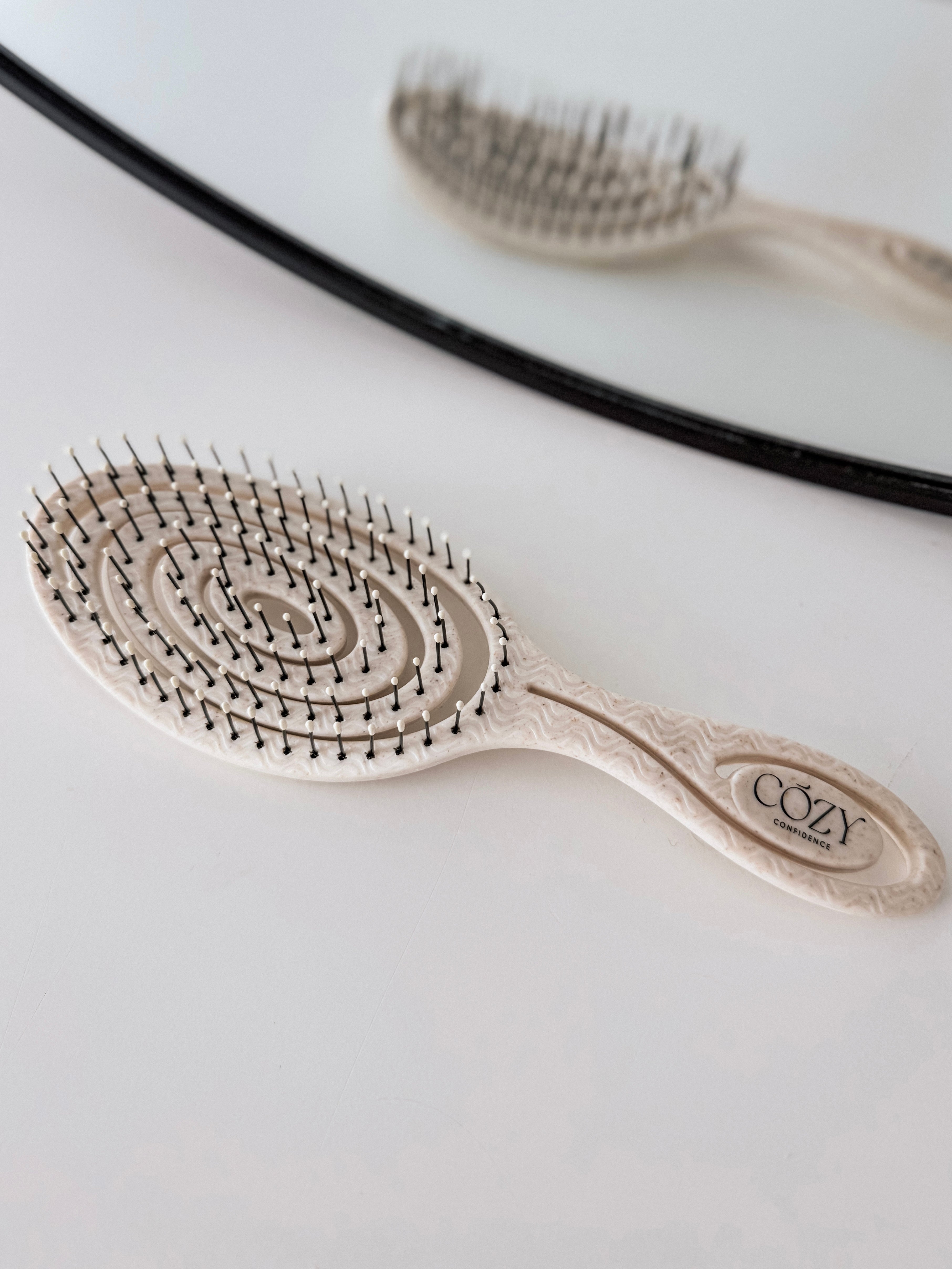 Oatmeal Volume Brush included in the Oatmeal Curl Kit for heatless curls, shown beside a round mirror