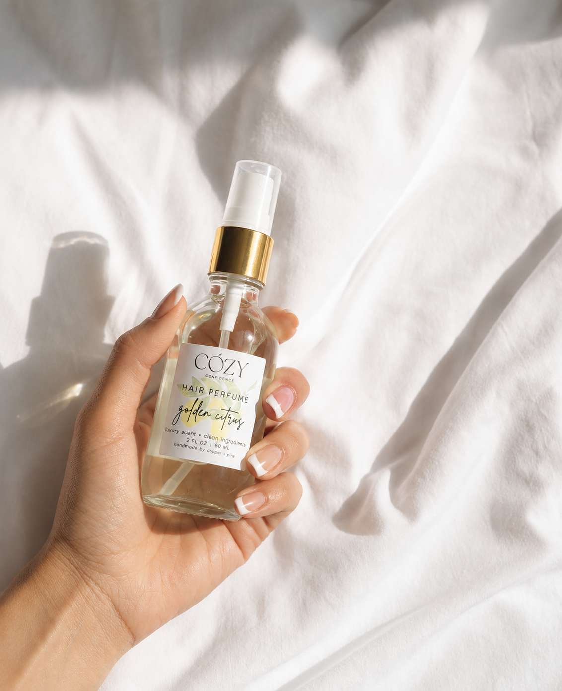 A clear glass bottle of non-toxic safe fragrance for hair, body and home.  Rich golden citrus scent.