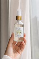 A clear glass bottle of non-toxic safe fragrance for hair, body and home.  Rich golden citrus scent.