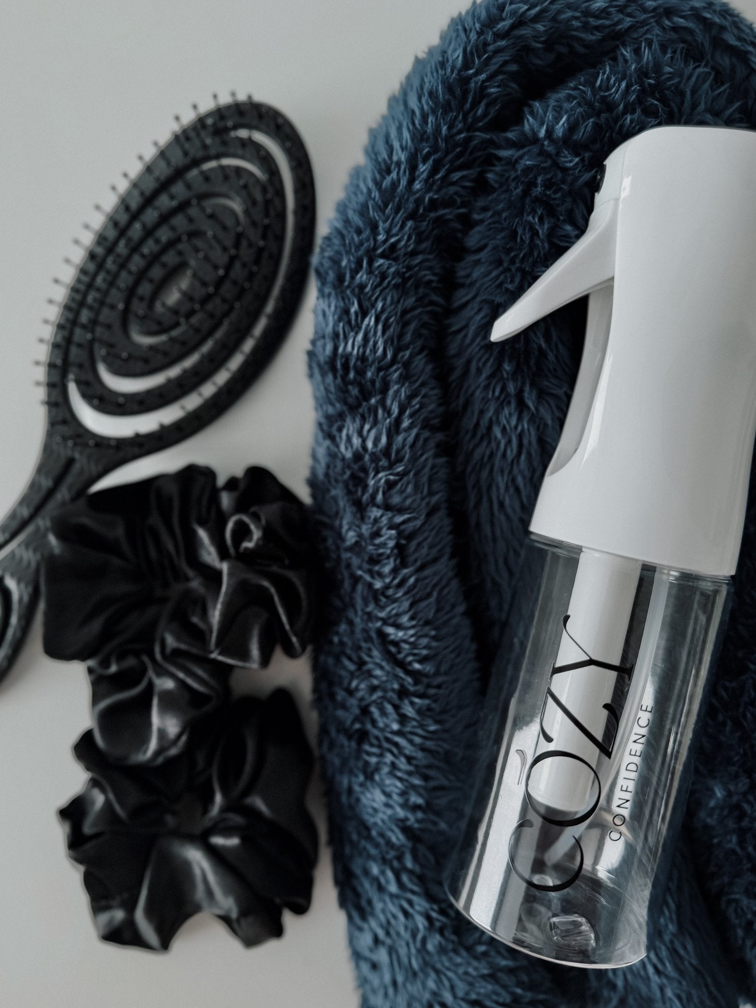 Midnight Curl Kit for heatless curls with a navy blue fluffy CurlBand, black silk scrunchies, black Volume Brush and white Cozy Confidence spray bottle