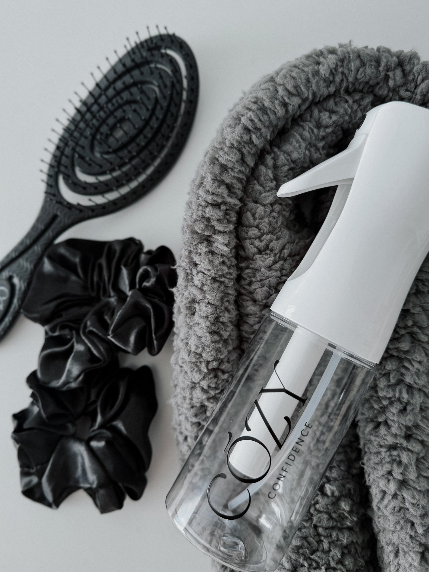 Slate Curl Kit for heatless curls with a gray fluffy CurlBand, black silk scrunchies, black Volume Brush and white Cozy Confidence spray bottle